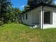 A spacious backyard features green grass and view of the screened in room on the house at 4241 E Palifox St, Tampa, FL 33610