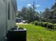 Backyard featuring an AC unit and green grass and foliage at 4241 E Palifox St, Tampa, FL 33610