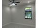 Bright bedroom featuring modern ceiling fan, large window and sleek flooring at 4241 E Palifox St, Tampa, FL 33610