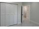 Bedroom featuring white folding closet doors and view into hall with gray marble flooring at 4241 E Palifox St, Tampa, FL 33610