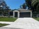 Charming single-story home with a well-manicured lawn and a spacious driveway leading to a two-car garage at 4241 E Palifox St, Tampa, FL 33610