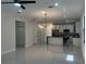 Bright and airy living room flows into the kitchen, featuring modern light fixture and sleek flooring at 4241 E Palifox St, Tampa, FL 33610