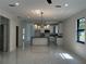Bright open-concept living area with a modern kitchen, white cabinets, black countertops, and marble floors at 4241 E Palifox St, Tampa, FL 33610