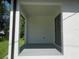 An outdoor porch offers a sheltered area with a neutral-colored floor and an entry door at 4241 E Palifox St, Tampa, FL 33610