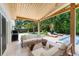 Stylish covered patio with outdoor lounge, grill, and pool view, ideal for entertaining and relaxation at 4618 Bayshore Ne Blvd, St Petersburg, FL 33703
