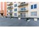 Multiple balconies with white railings on a tan building with potted plants on the patio at 4900 Brittany S Dr # 209, St Petersburg, FL 33715