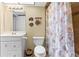 Cozy bathroom featuring a vanity, toilet, and a seashell themed shower curtain for a beachy vibe at 4900 Brittany S Dr # 209, St Petersburg, FL 33715