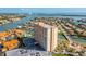 View of the high-rise condominium building with a parking lot and surrounding waterfront homes at 4900 Brittany S Dr # 209, St Petersburg, FL 33715
