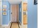 Cozy condo entryway featuring light blue walls, beach themed art, and a wood-look door at 4900 Brittany S Dr # 209, St Petersburg, FL 33715