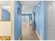 Hallway with beach decor, neutral tile, and blue walls leading to the living space at 4900 Brittany S Dr # 209, St Petersburg, FL 33715