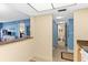 Hallway featuring beige walls, blue accents, and tile flooring leading to bath and living space at 4900 Brittany S Dr # 209, St Petersburg, FL 33715
