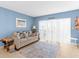 Bright living room featuring a comfortable couch and sliding glass doors offering ample natural light at 4900 Brittany S Dr # 209, St Petersburg, FL 33715