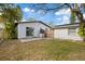Backyard features a concrete patio, lawn, and white building with a sliding glass door at 5013 W Mccoy St, Tampa, FL 33616