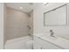 Modern bathroom featuring a shower with neutral-colored tile and a vanity with white countertops at 5013 W Mccoy St, Tampa, FL 33616