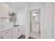 Bright kitchenette with white cabinetry and a view to a sleek bathroom at 5013 W Mccoy St, Tampa, FL 33616