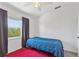 Bright bedroom features a ceiling fan, a large window and a red rug on the floor at 5435 Sweetwater Terrace Cir, Tampa, FL 33634