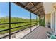 Screened patio has wood flooring and view of luscious green trees at 5435 Sweetwater Terrace Cir, Tampa, FL 33634