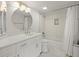 Bright bathroom with a tub, shower, modern sink, and large, round mirror at 5700 Escondida S Blvd # 401, St Petersburg, FL 33715