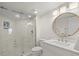 Bright bathroom with a glass enclosed shower, modern fixtures, and a round mirror at 5700 Escondida S Blvd # 401, St Petersburg, FL 33715