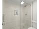 Modern bathroom featuring a glass enclosed shower with light grey tiling and a convenient inset shelf at 5700 Escondida S Blvd # 401, St Petersburg, FL 33715