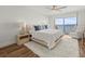 Relaxing bedroom with wood floors, a king bed, ceiling fan, and waterfront balcony access at 5700 Escondida S Blvd # 401, St Petersburg, FL 33715