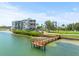 Waterfront condo building featuring a private dock and serene water views for an idyllic coastal living experience at 5700 Escondida S Blvd # 401, St Petersburg, FL 33715