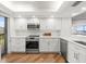 Bright kitchen features stainless steel appliances, white cabinets, and a hardwood floor at 5700 Escondida S Blvd # 401, St Petersburg, FL 33715