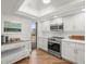 Well lit kitchen featuring stainless steel appliances, recessed lighting and white cabinets at 5700 Escondida S Blvd # 401, St Petersburg, FL 33715