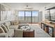 Comfortable living room featuring a modern design, cozy seating, and access to a beautiful water view from the balcony at 5700 Escondida S Blvd # 401, St Petersburg, FL 33715