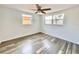 Spacious bedroom featuring a ceiling fan, and wood-look laminate flooring at 5703 Andrea Dr, Holiday, FL 34690