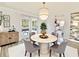 Bright dining area featuring a round marble table, stylish chairs, modern lighting, and sliding glass doors at 5703 Andrea Dr, Holiday, FL 34690