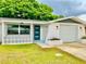 Charming single-story home featuring a well-manicured lawn, bright white exterior, and a stylish blue front door at 5703 Andrea Dr, Holiday, FL 34690