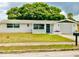 Well-maintained single-story home with a manicured front yard and attached garage at 5703 Andrea Dr, Holiday, FL 34690