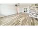 Bright living room with light wood floors, a modern ceiling fan, and a stacked stone accent wall at 5703 Andrea Dr, Holiday, FL 34690