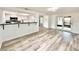 Open-concept living area with bar seating, white cabinetry in the kitchen, and sliding doors to the outside at 5703 Andrea Dr, Holiday, FL 34690