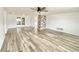 Bright living room with light wood floors, a modern ceiling fan, and a stacked stone accent wall at 5703 Andrea Dr, Holiday, FL 34690