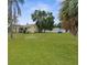 Sprawling backyard featuring a lush lawn and mature trees, ideal for outdoor activities at 6028 Central Ave, New Port Richey, FL 34653