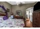 Bedroom with a floral bedspread, and ornate dark wood dressers, with a view to the ensuite at 6028 Central Ave, New Port Richey, FL 34653