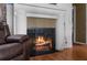 A cozy fireplace with a white brick surround and a decorative metal screen at 6028 Central Ave, New Port Richey, FL 34653