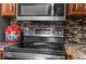 Kitchen featuring stainless steel oven and microwave over stone countertop at 6028 Central Ave, New Port Richey, FL 34653