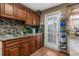Kitchen featuring wood cabinets, mosaic backsplash, and stainless steel sink at 6028 Central Ave, New Port Richey, FL 34653