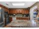 Well-lit kitchen featuring wood cabinetry, stone countertops, and stainless steel appliances at 6028 Central Ave, New Port Richey, FL 34653