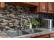 Close-up of a stainless steel sink with a modern faucet and mosaic backsplash at 6028 Central Ave, New Port Richey, FL 34653