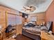 Cozy bedroom featuring wood walls, a ceiling fan, and a comfortable atmosphere at 6726 Udell Ln, Hudson, FL 34667