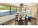 Bright dining room with large windows, ceiling fan, and wood floors overlooking lush greenery at 6726 Udell Ln, Hudson, FL 34667