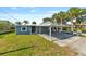 A cozy one-story home with a covered carport, a well-maintained lawn, and mature palm trees at 6726 Udell Ln, Hudson, FL 34667