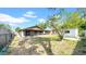 Backyard view featuring a screened-in patio, grass area, and shed at 6915 N Hubert Ave, Tampa, FL 33614