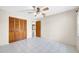 This comfortable bedroom features tile floors, a wooden closet door, and a ceiling fan at 6915 N Hubert Ave, Tampa, FL 33614