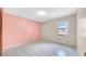 Cozy bedroom with a pastel pink wall, a window with bars, and tile flooring at 6915 N Hubert Ave, Tampa, FL 33614