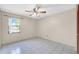 Relaxing bedroom with neutral colors, a ceiling fan, and a window with bars at 6915 N Hubert Ave, Tampa, FL 33614